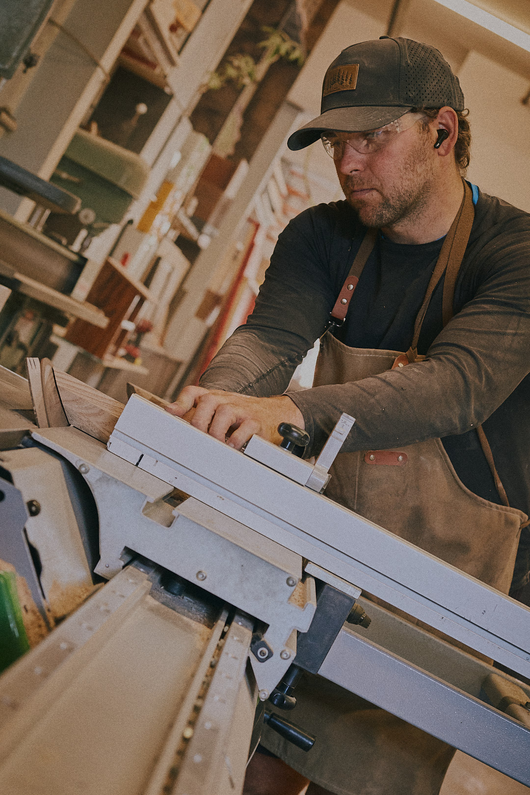 Ben at the table saw, close detail showing focused craft work in the studio.